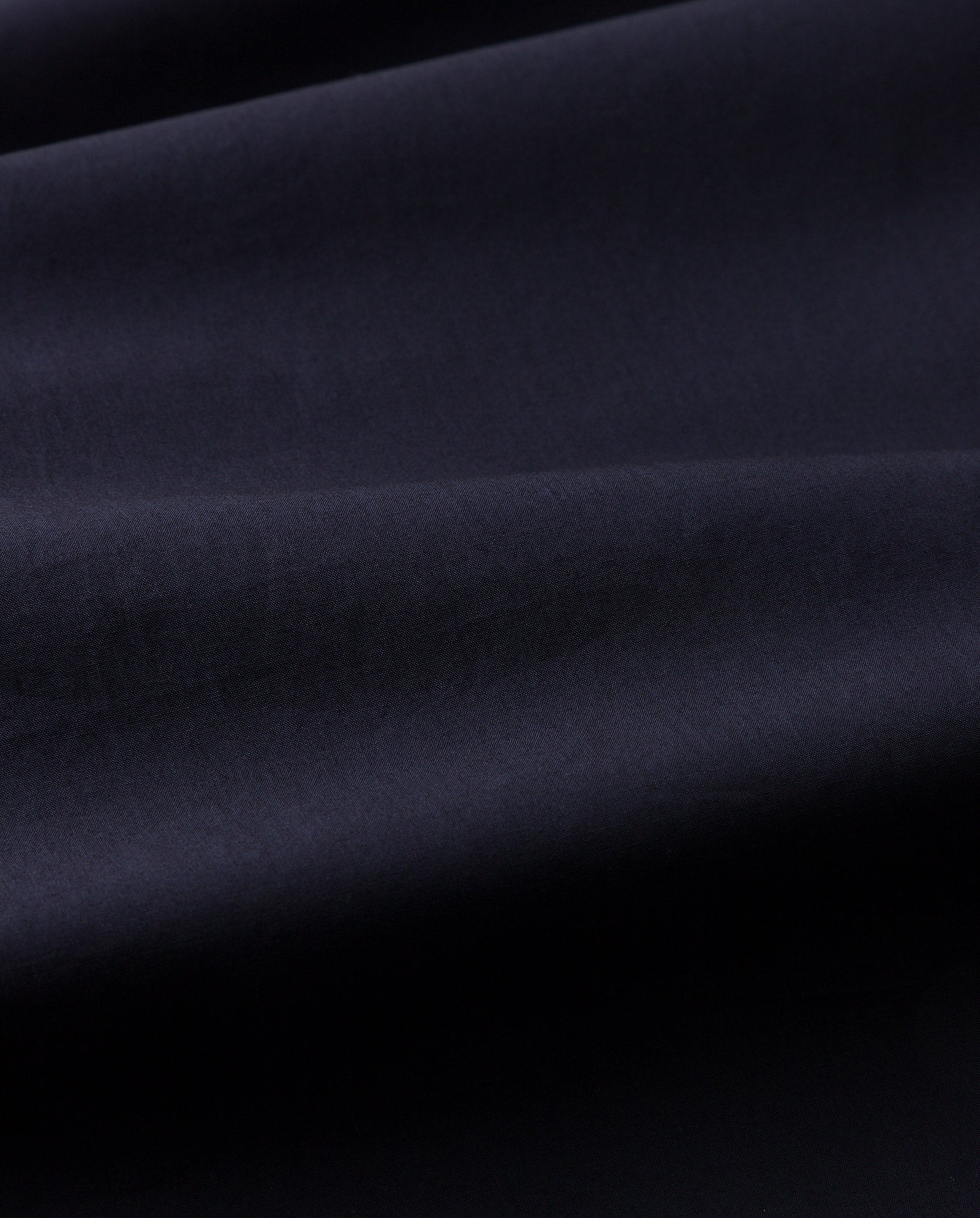 Close-up of the IVY OAK NICOLINA Dress in dark navy, showcasing soft folds, a subtle sheen, and elegant adjustable straps.