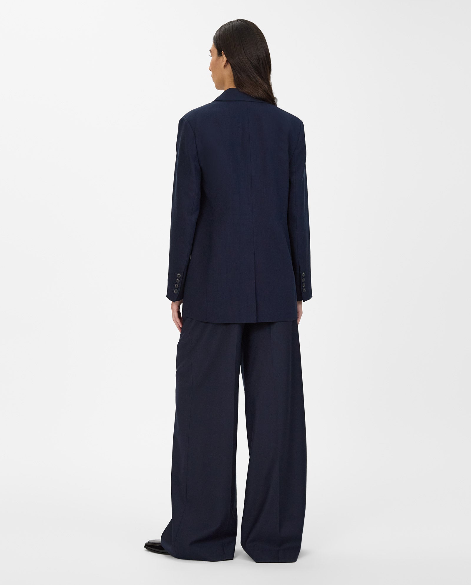 A person with long dark hair wears the IVY OAK JUNA Blazer and matching trousers, both oversized in navy, shown from the back against a plain white background.