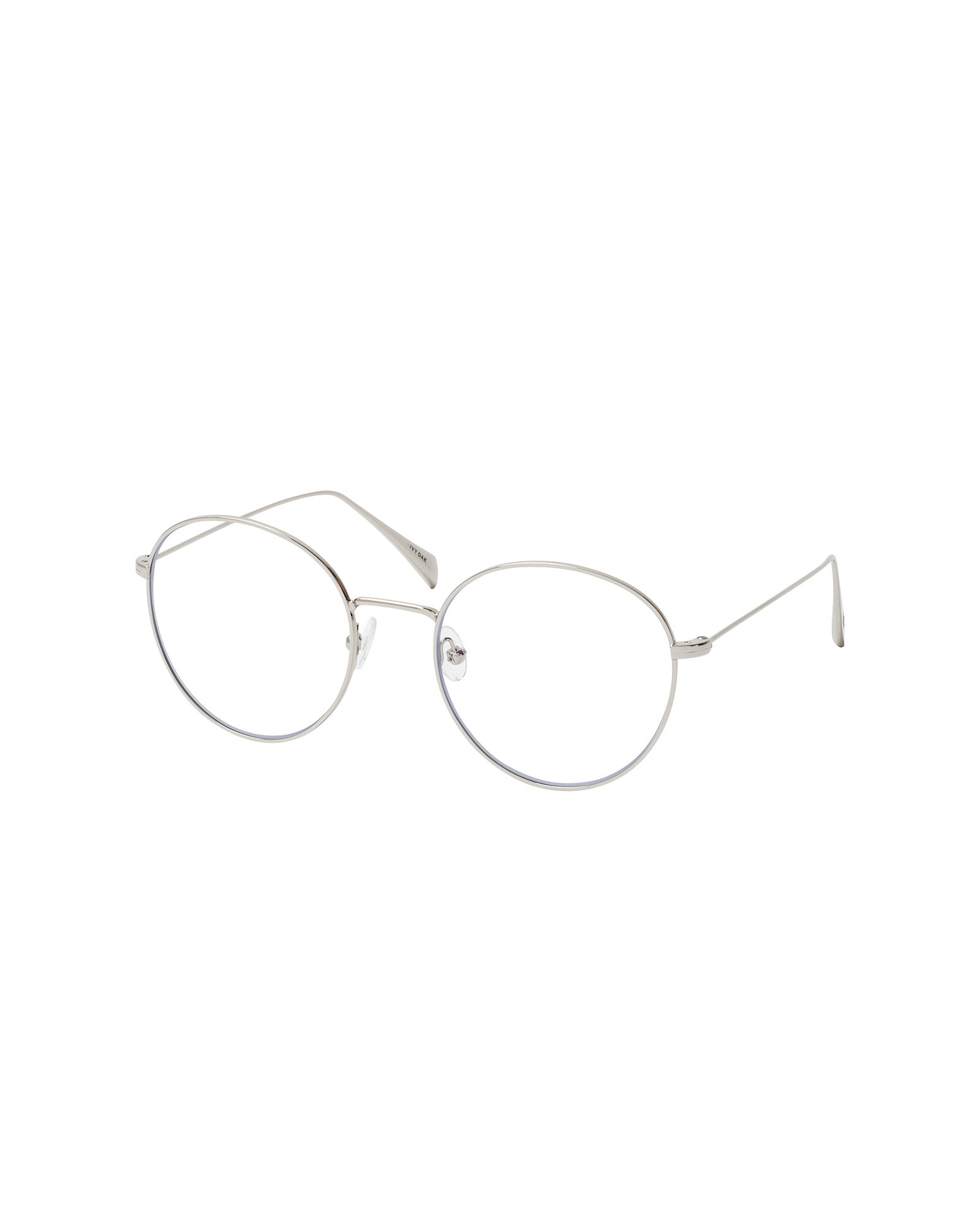 The Aileen Glasses by IVY OAK feature thin silver metal frames in an oval shape with clear lenses, crafted from recycled materials for an eco-friendly touch, shown against a white background.