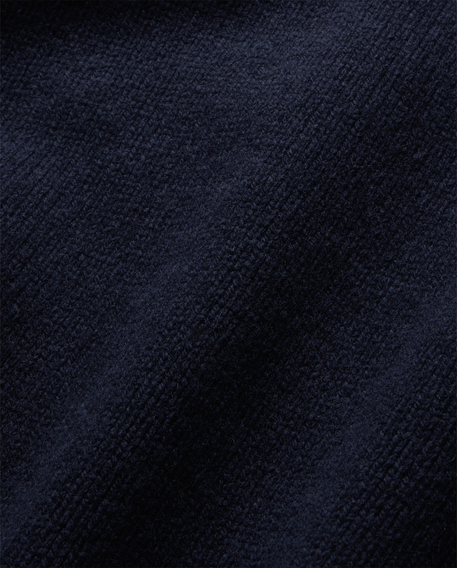 Close-up of the KASSIDY Jumper by IVY OAK, featuring dark navy blue textured fabric with soft, raised fibers and gentle folds that evoke a cozy, cashmere-like feel.