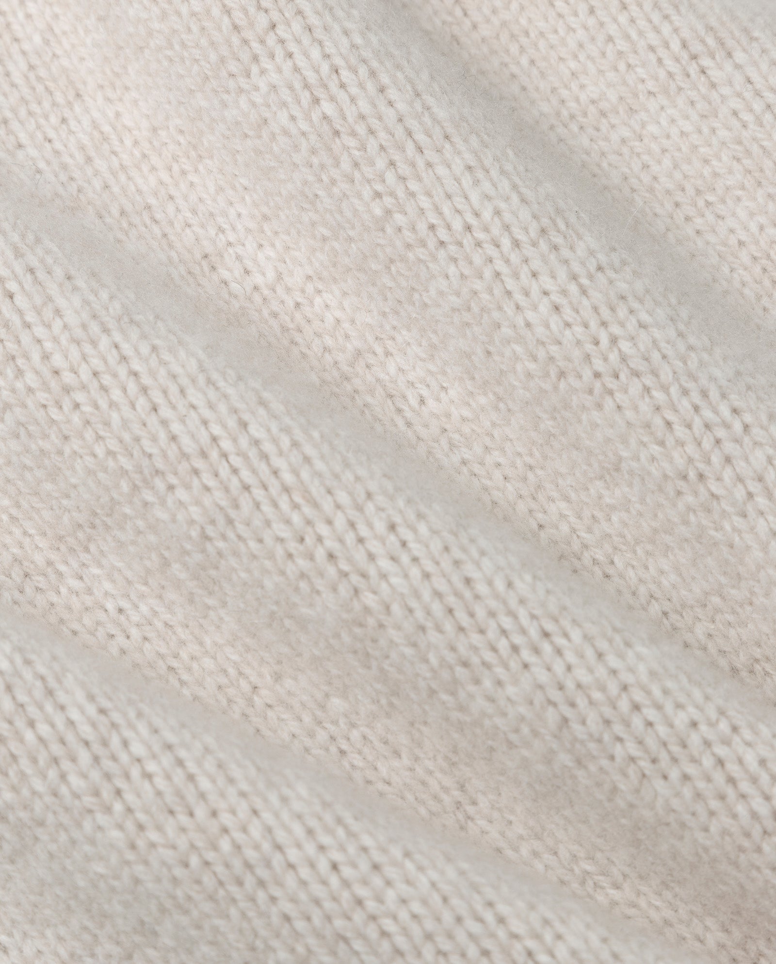 Close-up of the IVY OAK KARMA Cardigan, a soft beige cashmere-blend piece featuring a diagonal ribbed texture.