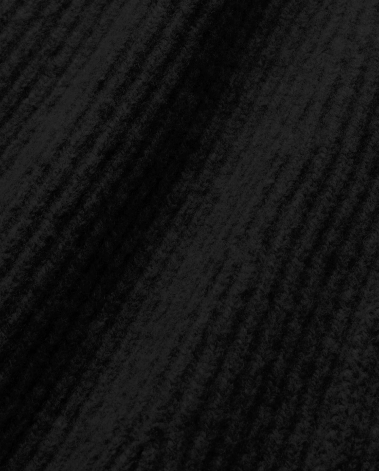 Close-up of the KEENA Skirt by IVY OAK in black corduroy, showcasing exposed seams that emphasize its textured, ridged pattern and soft finish.