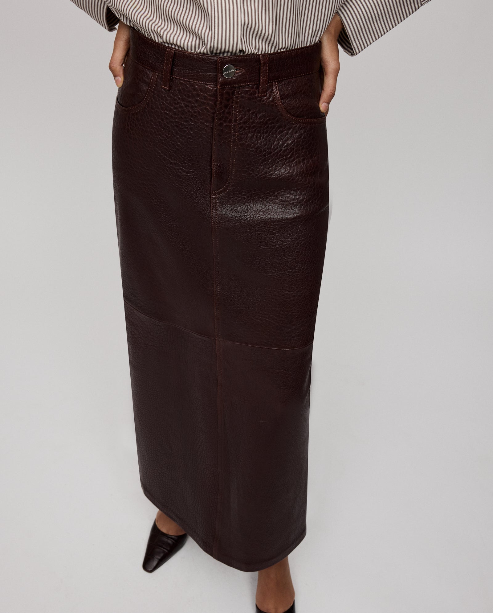 A person in the IVY OAK LISANNE Skirt, paired with a striped shirt and pointed shoes, stands against a plain background.
