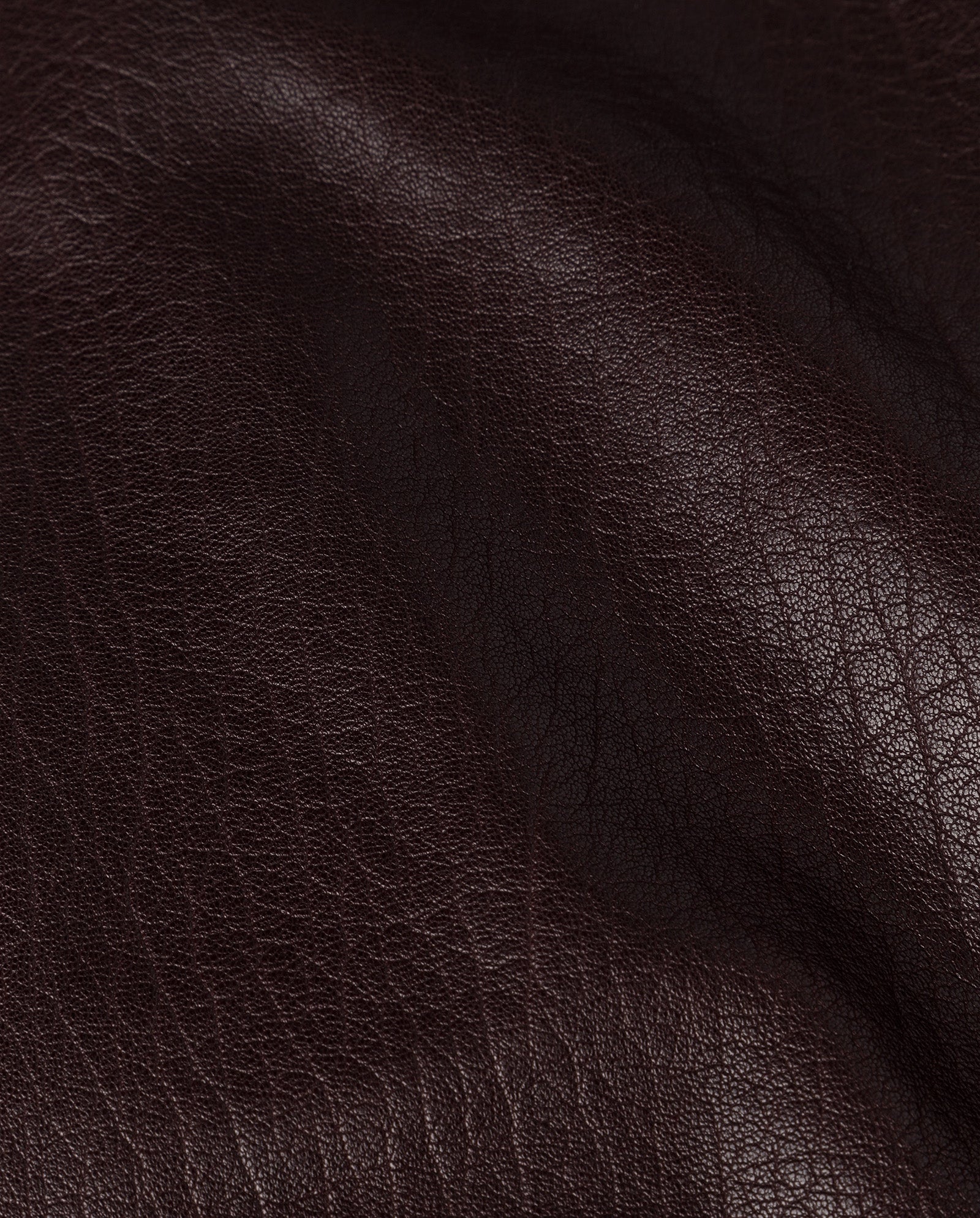Close-up of the IVY OAK LISANNE Skirt in dark brown leather with visible texture and natural creases, crafted from premium hide—perfect for an A-line silhouette or ankle-length style.